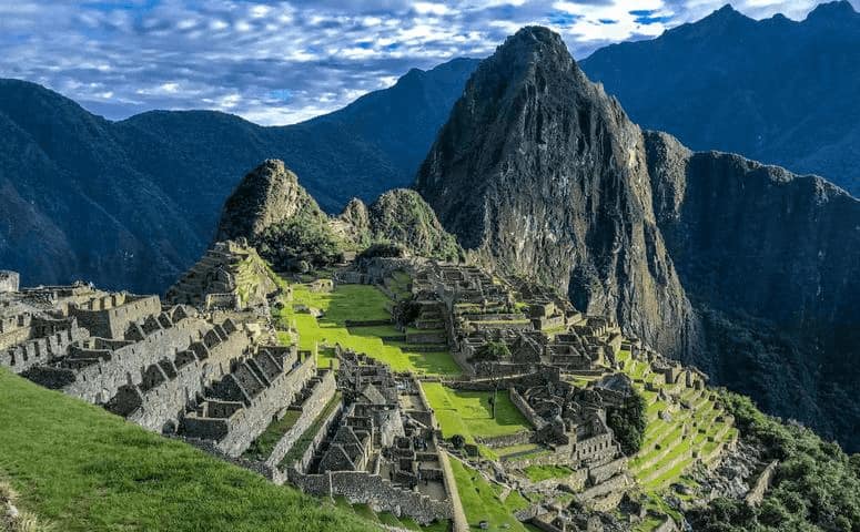 Peru Itinerary - How to Structure Your Peru Itinerary View onto the ruins of Machu Picchu in Peru.