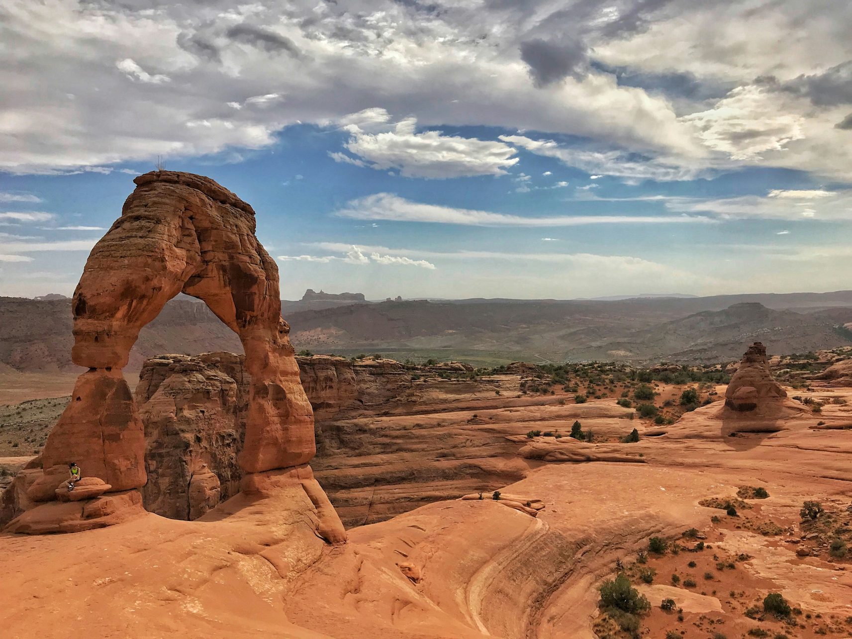 - Thrill-Seeker's Guide: Top Destinations for the Bold & Brave Sitting at the Delicate Arch Trail, Moab, UT, USA.