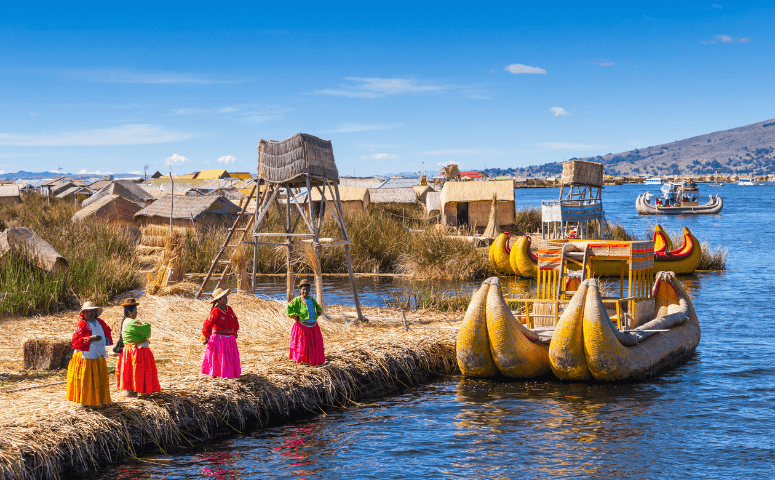 Peru Itinerary - How to Structure Your Peru Itinerary Women and traditional boat at Lake Titicaca in Peru.