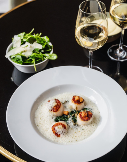A fancy lunch featuring succulent Saint Jacques at the Monsieur Bleu restaurant in Paris, France.